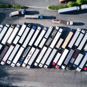 A bird's eye view of about two dozens of moving trucks.