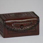 A small wooden chest on a white surface.