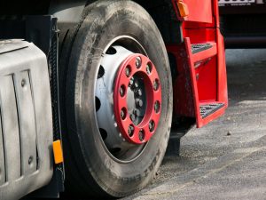 A picture of a red moving truck, zoomed into one of the wheels.