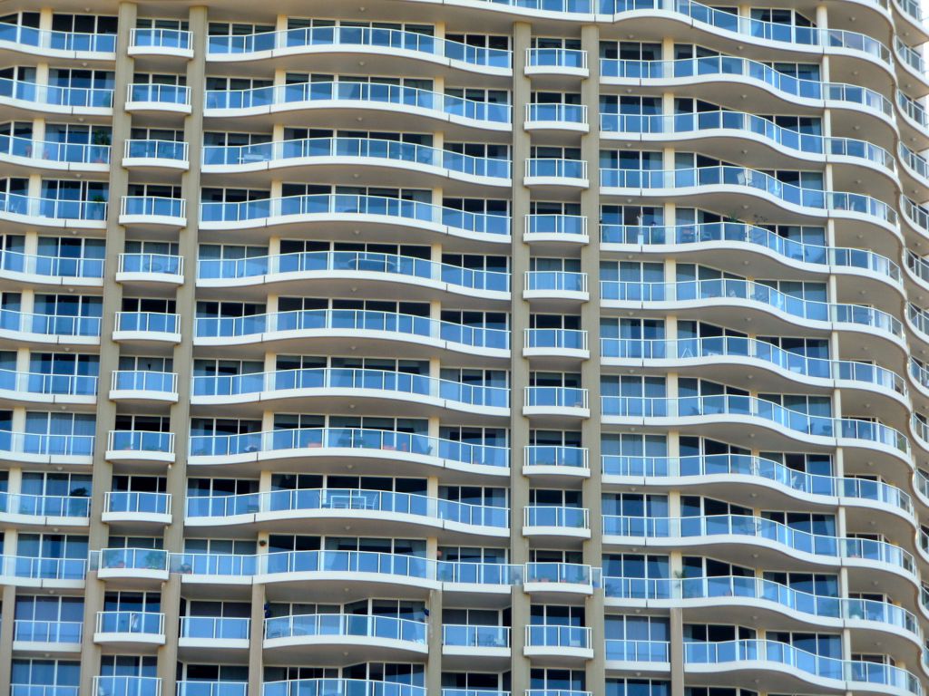 A tall glass apartment building, representing a cheap apartment for rent in Miami.