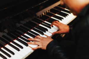 Close up of a man playing a piano.