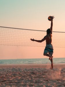 man playing beach volleyball during daytime