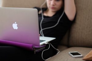 woman sitting on sofa with Mac Book Air