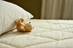 A teddy bear on the bed.